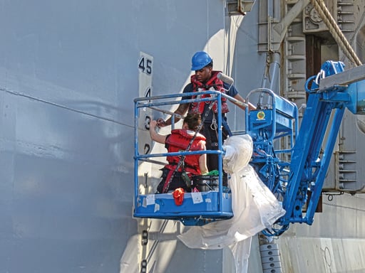 Manlifts, floating scaffolding, and high-reach lift mounts off large barges are use to coat ship while in the water.